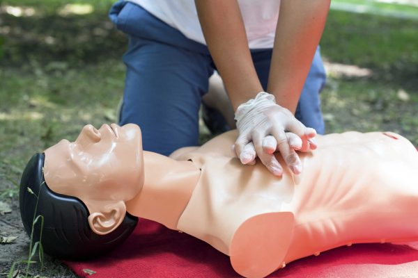 Student is perfoming CPR on a training manikin.